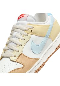 Zapatillas Nike con cuero blanco, amarillo y azul claro, acentos de cuero texturizado en color marrón, puntera redonda, lengua acolchada y suela de goma beige.