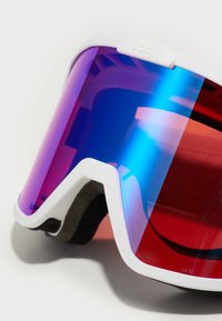 Ski-imeed koos valge raami, violetse kuni sinise gradient objektiiviga ja mugavuse tagamiseks musta vahtmaterjaliga. Reguleeritav rihm on lisatud.