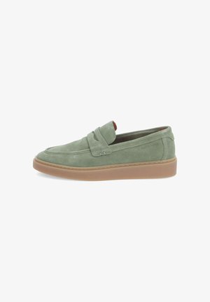 Green suede slip-on shoes with a rounded toe, stitched detailing, and a tan rubber sole. Minimalist design with a comfortable fit.