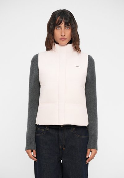 Gilet rembourré en rose clair, avec un col haut et une manche longue grise en dessous. Texture lisse avec un minimum de branding sur la poitrine.