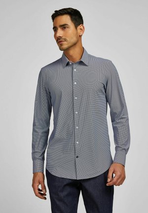 Chemise à manches longues bleu foncé avec un motif à carreaux, dotée d'un col pointu, d'une fermeture à boutons à l'avant et de boutons contrastants.