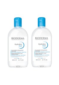 Bioderma Hydrabio H2O, due bottiglie trasparenti da 500 ml con tappi blu. Le etichette mostrano uno sfondo bianco e testi blu che descrivono gli utilizzi del prodotto.