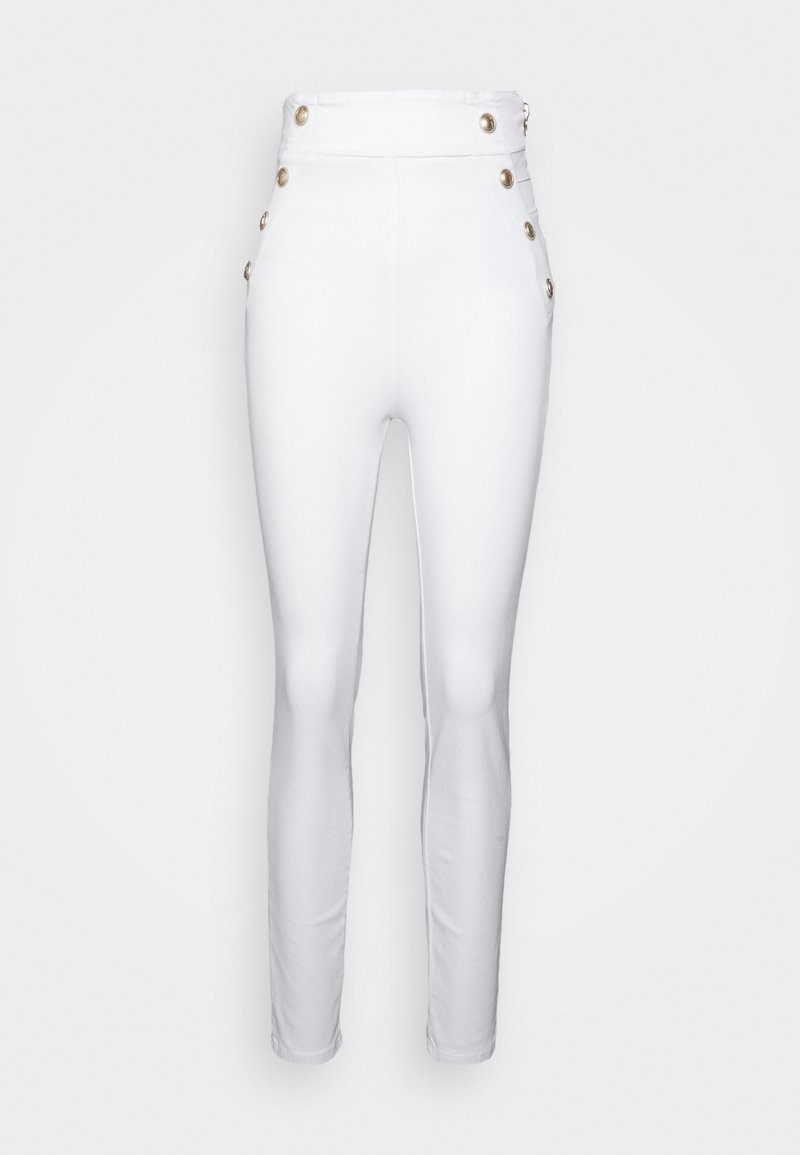 Valkoiset korkea vyötäröiset housut, jotka on valmistettu joustavasta kankaasta. Vyötäröllä on kultaiset napit ja sivutaskut. Slim fit -malli lahkeissa.