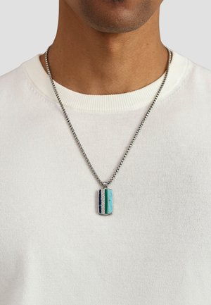 Sølvkæde med et rektangulært vedhæng, der har turkis, blå og grønne striber samt sølvdetaljer.