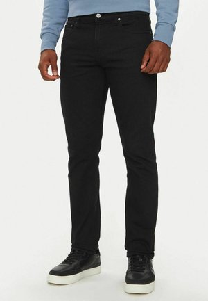 Jeans in denim neri con vestibilità slim, caratterizzati da un classico design a cinque tasche e hardware argentato. Abbinati a sneakers nere.