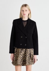 Melna, īsa, dubultā spiediena jaka ar lieliem atloka, divām priekšējām kabatām, apvienota ar leoparda raksta plīsušo svārku. Gluda tekstūra.