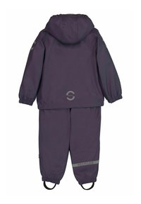 Completo da pioggia viola realizzato in materiale riciclato. Presenta una vita elastica, polsini, cappuccio e un accento riflettente "RICICLATO" sui pantaloni.