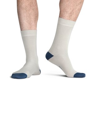 Beige pamut zokni sötétkék orral és sarokkal. Bordázott szegéllyel és sima textúrával rendelkezik. Szabványos crew hosszúságú kialakítás.