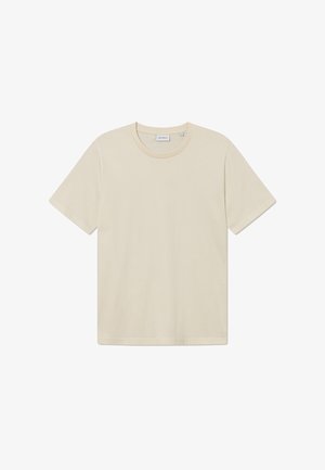 Gaiši beigy īsās piedurknes T-krekls ar apaļu kakla izgriezumu, izgatavots no mīksta kokvilnas auduma. Tam ir brīvs piegriezums un minimālisma dizains.