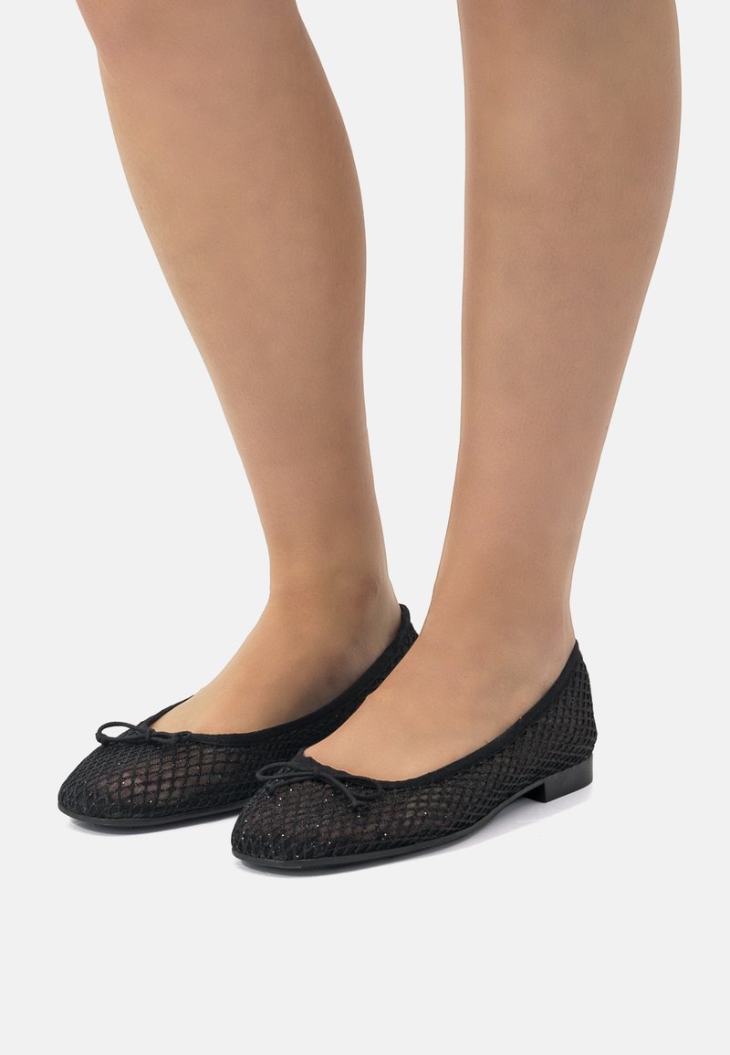 Ballerines en maille noire avec un bout arrondi, un détail de nœud à l'avant et un petit talon. Matériau texturé avec un design à tissage ouvert.