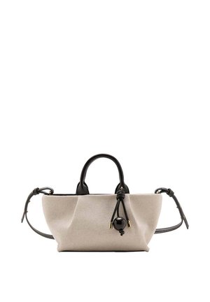 Bolso de mano de lona beige con asas de cuero negro y correa de hombro ajustable, con detalle decorativo de cuenta negra y nudo.