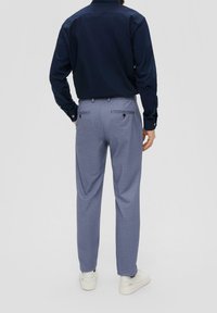 Námořnická košile s dlouhým rukávem v kombinaci se šedými kostkovanými kalhotami se slim fit střihem, bočními kapsami a zadními kapsami se zapínáním na knoflíky. Bílé tenisky.