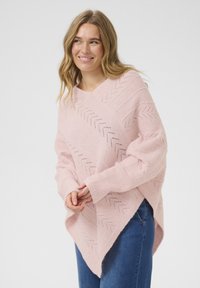 Svetle růžový pletený poncho s chevron vzorem, designem do V, širokými rukávy, doplněné jemnou texturou a volným střihem.
