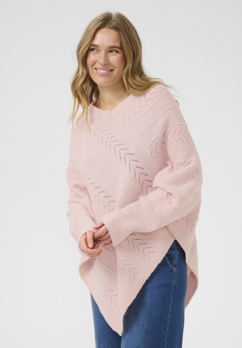 Svetle růžový pletený poncho s chevron vzorem, designem do V, širokými rukávy, doplněné jemnou texturou a volným střihem.