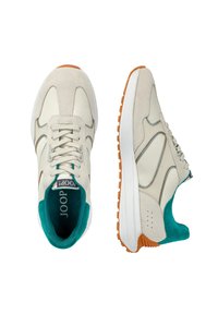 Beige Sneaker aus Leder und Wildleder, mit einem tealfarbenen Innenraum, orangefarbener Gummisohle und einem markanten, geschwungenen Paneeldesign.