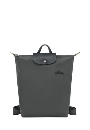 Gray nylon backpack with a textured black leather flap, adjustable straps, and a top handle. Features a silver snap closure and logo detail.