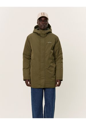 Olive green, padded jacket with a high collar and hood, zip closure, and "LES DEUX" branding, worn over blue denim jeans.