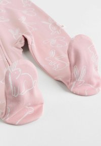 Rosa Fuß-Pyjamas mit einem Hasenmuster in Weiß. Weicher, dehnbarer Stoff mit abgerundeten Füßen für zusätzlichen Komfort.