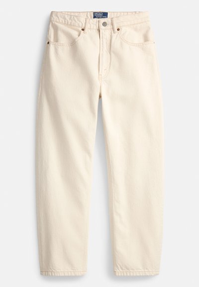 Krém színű farmernadrág, egyenes szárú fazonnal, elülső zsebekkel és felső varrással díszítve. Fém gombos és cipzáros megoldás.