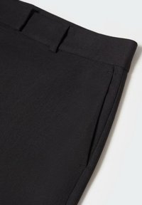 Pantalon noir en tissu lisse, avec une coupe droite, une taille avec passants de ceinture et des poches latérales.