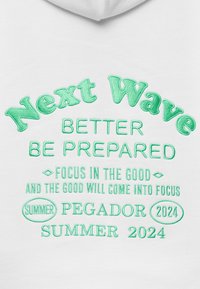 Bílá mikina s kapucí s zeleným vyšitým textem obsahujícím fráze jako "Next Wave," "Better Be Prepared" a "Summer 2024."