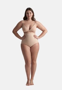 Beige tvådelad baddräkt med en V-ringad bralette med tunna axelremmar och högmidjade shorts, slät textur, minimalistisk design.