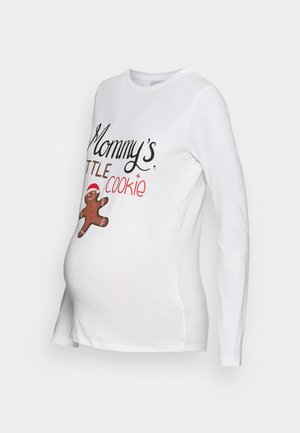 Hvid langærmet graviditetsbluse med teksten "Mommy's lille cookie" og en lille pebernødde-illustration foran.