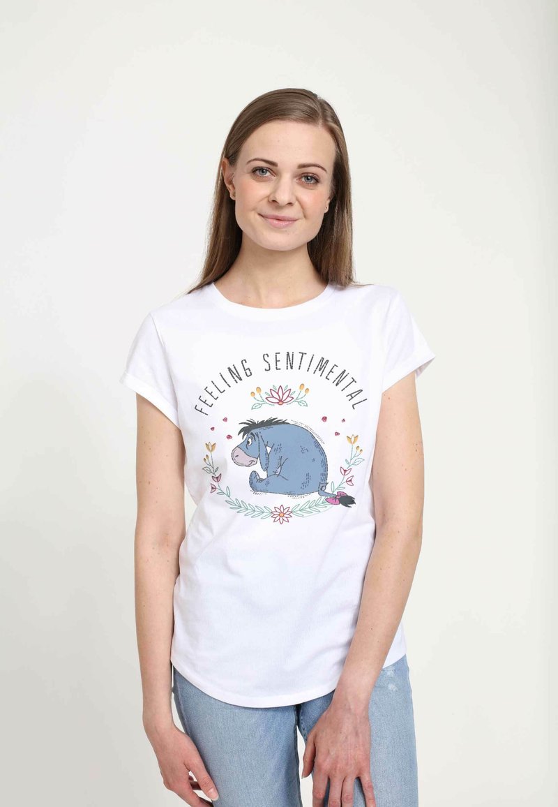 Bílá č Cotton tričko s grafikou modrého osla s květinovými akcenty a textem "Cítím se sentimentálně" v černém písmu.