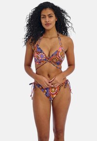 Kleurvolle bikini met een patronenontwerp in oranje, paars en blauw. Halternek met strikjes en bikini-broekjes met zijsstrik. Rekbare stof.