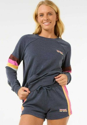 Sweatshirt- und Shorts-Set aus marineblauem Stoff. Mit mehrfarbigen Streifen an den Ärmeln und an den Seiten sowie einem Logo auf der Vorderseite des Shirts.
