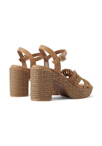 Sandali platform marroni con tacco in juta intrecciata e cinghie in pelle. Presenta una cinghia alla caviglia regolabile e un design aperto sulla punta. Dettagli texturizzati in tutto il prodotto.