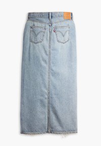 Jupe midi en denim bleu clair vue de dos, avec deux poches arrière, des passants de ceinture et un ourlet brut, non fini.