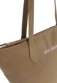 Bolso tote en tono beige con superficie texturizada, que cuenta con asas dobles, cierre de cremallera y un logotipo sutil en el panel frontal.