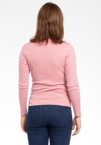 Maglietta attillata a maniche lunghe in morbido cotone rosa chiaro con scollatura rotonda, esposta da dietro su uno sfondo bianco.