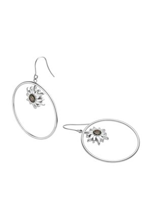 Silberne Creolen mit sonnenförmigen Mittelstücken, die dunkle, irisierende ovale Steine zeigen, auf weißem Hintergrund dargestellt.