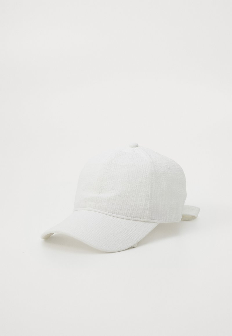 Gorra de béisbol blanca con una tela texturizada y visera curva. Presenta una correa ajustable en la parte posterior para personalizar el tamaño.