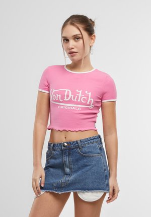 Crop top rose à manches courtes avec des finitions blanches contrastantes et le logo "Von Dutch Originals" ; associé à une jupe en denim bleue avec un ourlet effiloché.