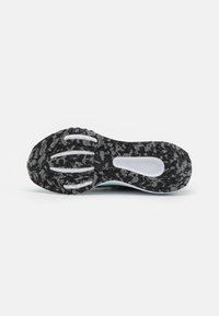 Zwarte sportieve schoenzool met een gekarteld textuurpatroon, witte rubberaccenten en een grijs camouflageontwerp. Vlakke, brede vorm voor stabiliteit.