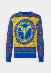 Felpa multicolore con un motivo blu, giallo e arancione, dotata di un design con emblematico centrale, polsini a coste e scollatura rotonda.