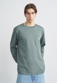 Πράσινο βαμβακερό πουκάμισο με μακριά μανίκια και στρογγυλή λαιμόκοψη, με τσέπη στο στήθος και μικρό λογότυπο. Κανονική εφαρμογή και απαλό ύφασμα.