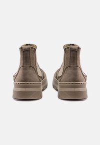 Botine din suede maro, cu panouri elastice pe laterale, guler căptușit și talpă din cauciuc texturată. Concepute cu un stil minimalist.