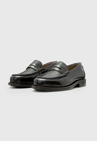 Men's black leather loafers with a textured leather panel, smooth finish, and a decorative band across the vamp, featuring a round toe and low heel.