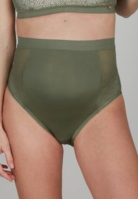 Culotte alta in verde oliva, con una texture liscia e pannelli in pizzo trasparente sui lati. Materiale in misto poliestere.