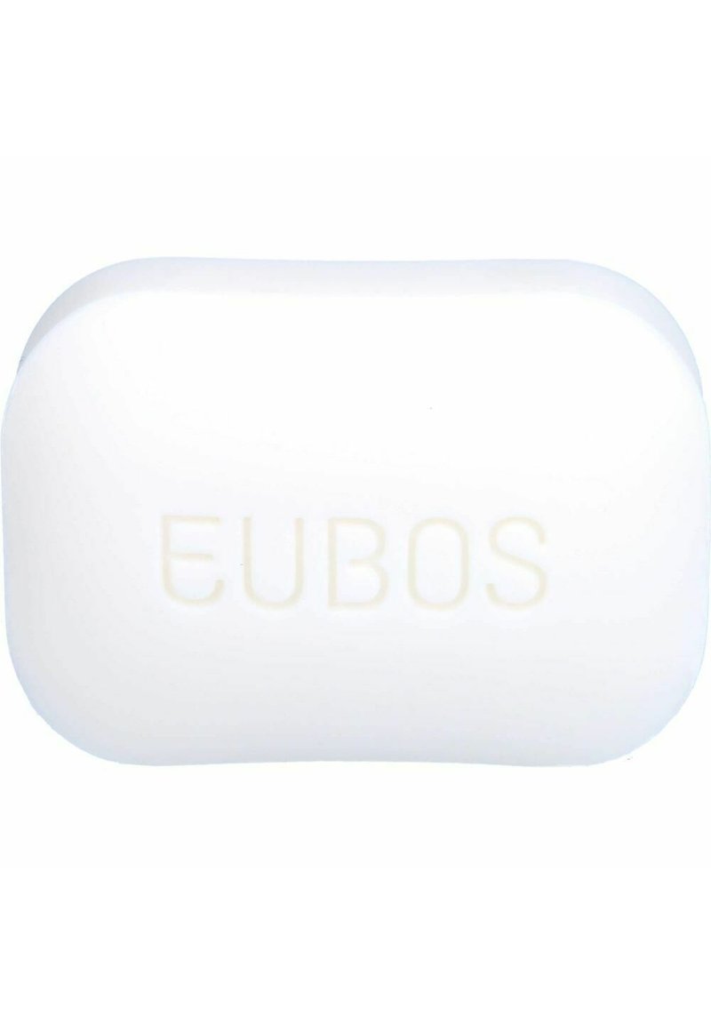 Ovaler weißer Seifenblock mit abgerundeten Ecken, der auf einer Seite ein erhabenes "EUBOS"-Markenlogo trägt. Glatte Textur mit glänzender Oberfläche.