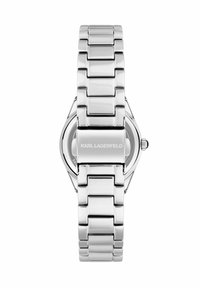 Montre-bracelet en métal argenté avec un bracelet à maillons, un boîtier rond et un cadran au design minimaliste. Le nom de la marque est gravé sur la boucle.