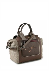 Handtasche aus braunem Leder und beigem strukturiertem Stoff mit zwei Griffen, einem abnehmbaren Riemen und einer Fronttasche mit Reißverschluss, die geprägten Text aufweist.