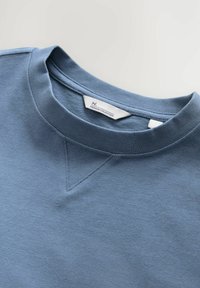 Lichtblauwe sweatshirt met ronde hals, voorzien van een subtiele V-naad detail bij de kraag. Gemaakt van zachte, gestructureerde stof. Label inbegrepen.