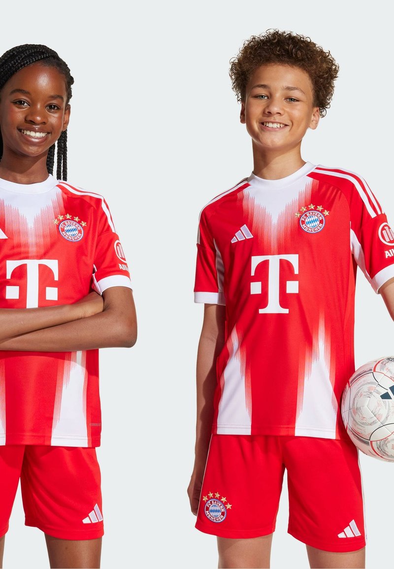 Røde og hvite fotballdrakter med korte ermer, gradientdesign, klubb-logo, og shorter med Adidas-logo og tre striper.