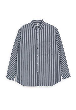 Skjorte med knapper foran med lodrette navyblå og hvide striber, krave, lange ærmer og brystlomme. Fremstillet af et letvægtsstof.