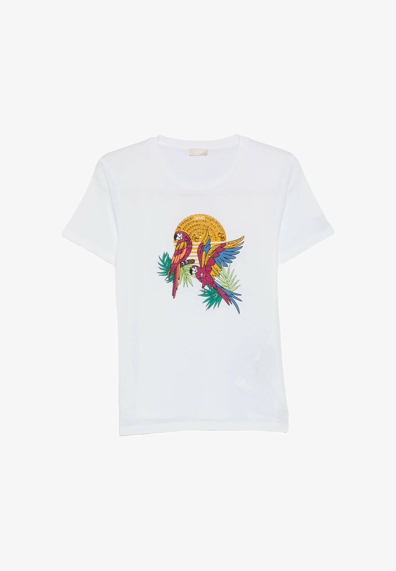 T-shirt blanc avec un graphisme coloré de perroquet perché sur des feuilles devant un soleil jaune, présentant des motifs complexes et des ailes éclatantes.